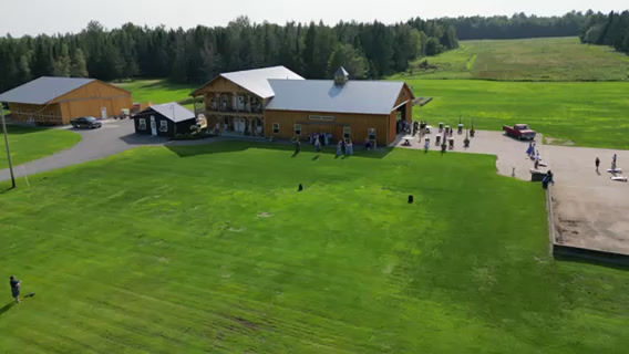 Aerial view of the Sunset Meadows barn, event barn and fields on 69 acres in Corinna, Maine