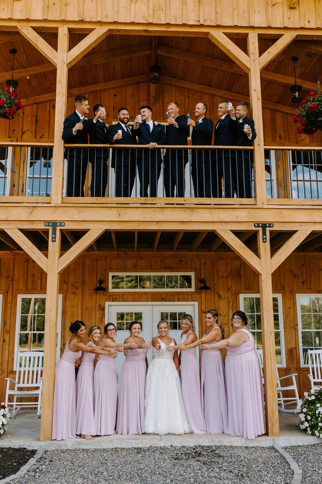 Wedding party toasting on the two-story barn porch at Sunset Meadows