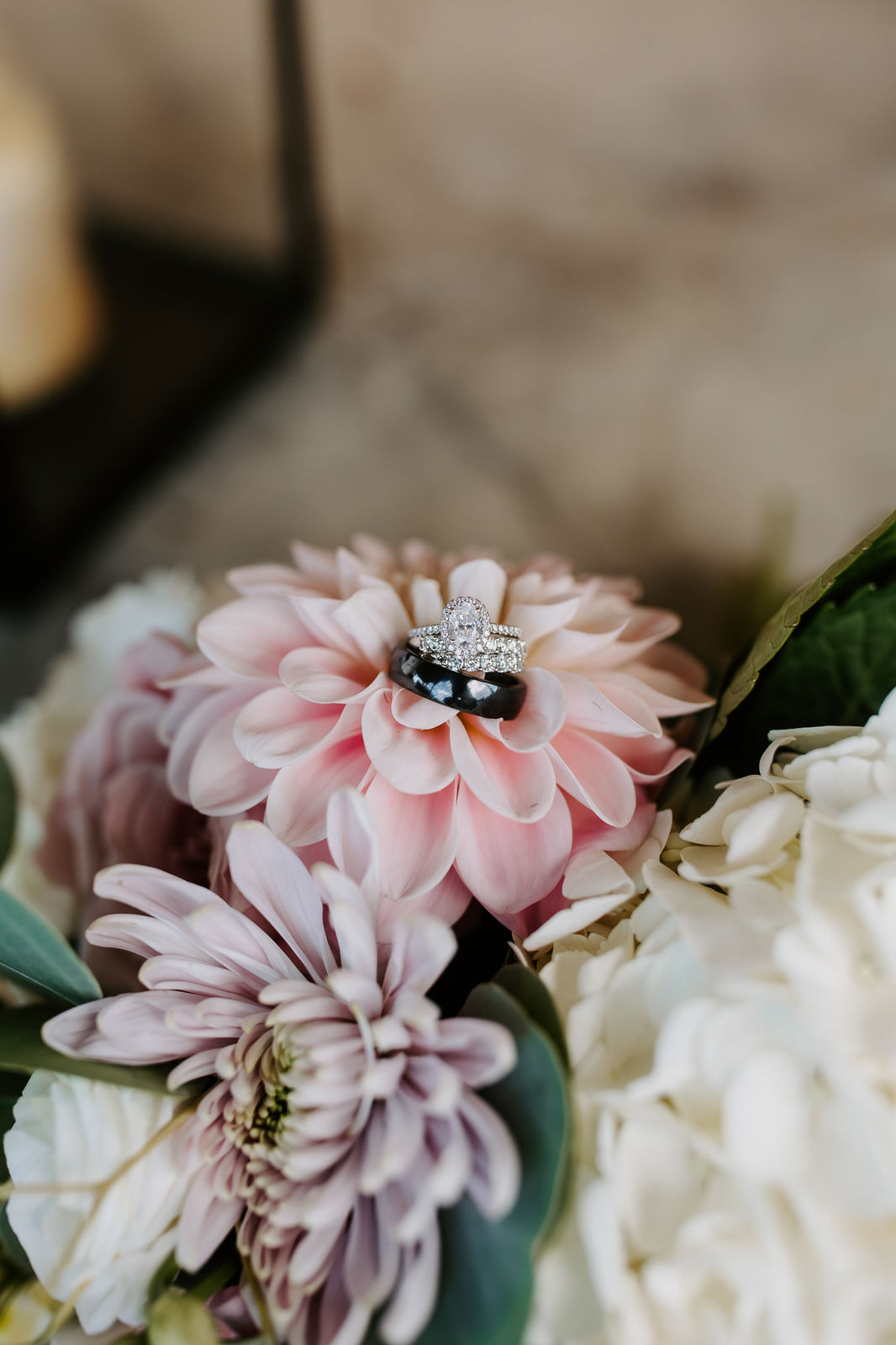 Wedding rings resting on blush dahlias