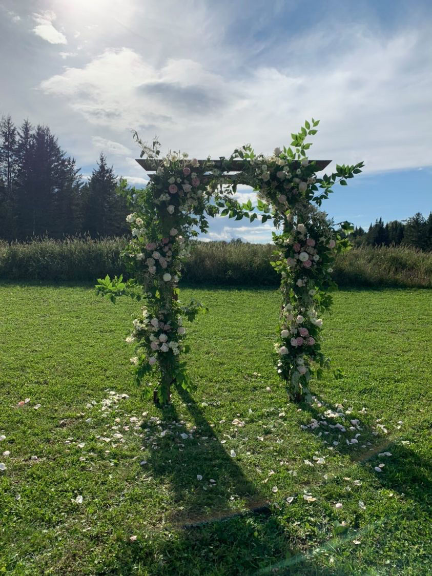 Floral ceremony arbor with rose petals in the meadow